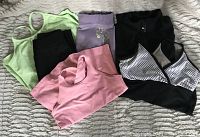 Complete lot showing three tops, pants, jacket, and skirt laid on bed.