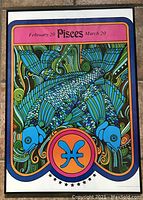 Full view of framed Pisces zodiac poster with bright blue fish and colorful psychedelic background.