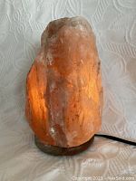 Himalayan salt lamp illuminated showing warm amber glow.