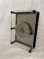 Front view of 3D metal pin art toy showing pins pressed to create a rounded 3D shape impression.