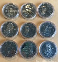 Top-down view of 9 silver-toned Canadian Salish Dollar coins from 1977 in round plastic cases showing various indigenous figures and symbols.
