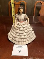 Front view of the figurine with measuring tape showing approximately 9 inches height.