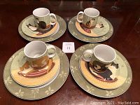 Four complete settings each with dinner plate, salad plate, and mug showing cat themed artwork and condition.