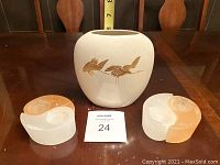Otagiri Japan vase with gold bird design with two glass candle holders placed on a wooden surface with tape measure behind showing the vase height.