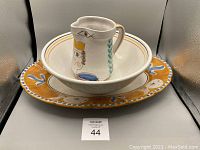 Front angled view showing the set of three items stacked: pitcher on bowl on serving plate, all displaying colorful and stylized patterns consistent with Solimene Vietri Italian porcelain.