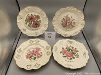Four Crown Davenport vintage decorative plates showing varied floral patterns and intricate pierced scalloped edges on light background.