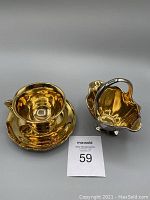 Golden Age cup, saucer, and creamer shown from above with reflective gold lustre finish