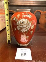 Front side view of the orange oval vase with gold relief floral and butterfly design, showing size approximately 6 inches tall.