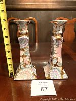 Front view of both floral candle holders with a tape measure showing approximately 8 1/4 inches height.