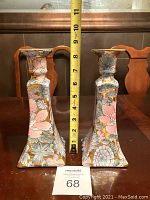 Pair of ceramic candle holders with floral Golden Peony pattern and measuring tape showing height approximately 8 3/4 inches.