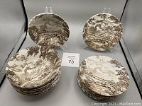 Photo of 8 bowls and 8 side plates from the Ridgway Country Days set showing brown rural landscape pattern on white ceramic.