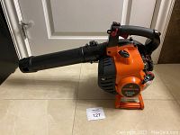 Orange Remington Ambush RM2BV leaf blower side view showing label and handle.