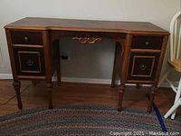 Front view of antique wooden office desk showing two drawers and carved detailing.