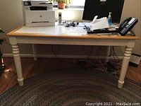 Full table with tile top and white legs with turned details, set with office items to show size and style.