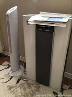 Nikken Power5 air purifier and Easy Home tower fan side by side in room setting.