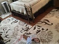 Two smaller matching area rugs placed near a bed and floor, showing floral brown patterns on beige background