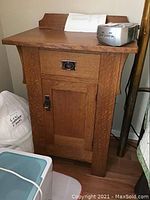 Front view of oak nightstand showing drawer, cabinet door, and wood grain.