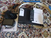 Sony DVD/CD player model DVP-SR201P with remote control, instruction manual, and related cabling and cords