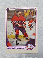 Photo of 1981 O-Pee-Chee Larry Robinson hockey card featuring Montreal Canadiens with autograph and visible wear.