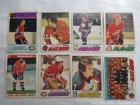 Eight vintage 1970s NHL hockey cards showing various players and a team photo. Cards include Guy Lafleur, Stan Mikita, Gary Sargent, David Shand, Michel Larocque, Rod Gilbert, and the 1977 Chicago Black Hawks team photo.