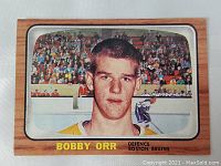 Front of the Bobby Orr rookie hockey card showcasing player image and wood-like frame with name and team.