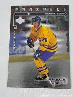 Front of 1998 Upper Deck Black Diamond Henrik Sedin hockey rookie card, showing action shot in Sweden yellow jersey and black diamond graphics.