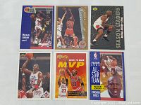 Top-down photo showing six Michael Jordan basketball cards from Fleer and related series in fair condition laid out on a flat surface.