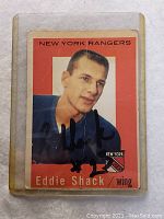 Front view of signed 1958-59 Topps Eddie Shack hockey card with New York Rangers uniform in protective sleeve.