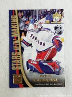 Front of Henrik Lundqvist rookie hockey card in New York Rangers uniform with gold foil text and NHL logos.