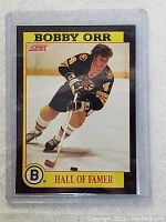 Front of Bobby Orr hockey card showing him skating in Bruins uniform with yellow bordered 'Hall of Famer' label.