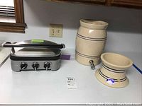 Photo showing Cuisinart Griddler and Marshall Pottery beverage dispenser with stand on table.