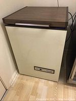 Front view of chest freezer showing the closed wood grain top and beige body.
