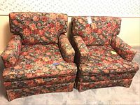 Pair of floral patterned upholstered armchairs side by side, showing overall shape, style, and condition.