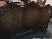 Full front view of headboard showing all three cane panels and carved top rail