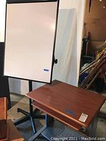 White board and rolling computer desk next to each other showing size and condition