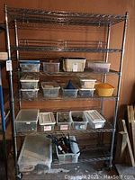 Full front view of metal wire shelving unit loaded with various plastic bins, hooks, and some tools showcasing shelf size and structure.