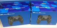 Two closed retail blue boxes featuring an image of a black wireless controller on front, labeled 'Wireless Controller'