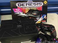 Photo of Sega Genesis Mini box, two game controllers (one classic style, one modern style), VR glasses box
