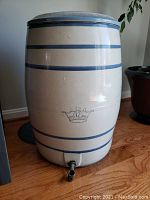 Full view of the 12 gallon stoneware water cooler crock. Shows cream color with blue bands and crown marking with number '12'. Includes matching lid.