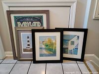 All four framed prints grouped on floor, showing different frames and art styles