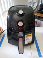 Front view of Bella air fryer showing timer and temperature knobs and handle with silver accent.
