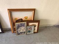 Five framed floral and jazz themed artworks, four prints and one large canvas piece, arranged on floor