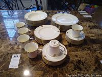 Overview of the complete set arranged on table, showing cups, saucers, bowls, dinner plates, salad bowls, and bread and butter plates.
