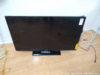 Full frontal view of the 51-inch Element television, showing the screen, stand, and remote placed on the base.