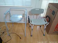 Photo showing both the portable toilet seat and shower seat placed side by side on a wooden floor near a window.