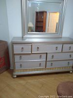Full view of chest of drawers with attached mirror, showing silver finish and drawer arrangement.