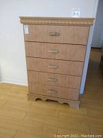 Full view of the 5-drawer composite wood dresser showing trim details and drawer handles.