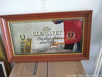 Full view of the Glenlivet bar mirror showing the wooden frame, reflective surface, and branding on the mirror.