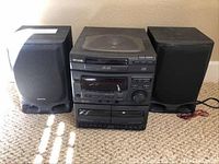 Full view of the Aiwa stereo system consisting of the main unit and two speakers placed side by side showing overall condition and setup.