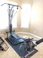 Assembled Bowflex Ultimate home gym on mat, showing main frame, bench and pull-up bar